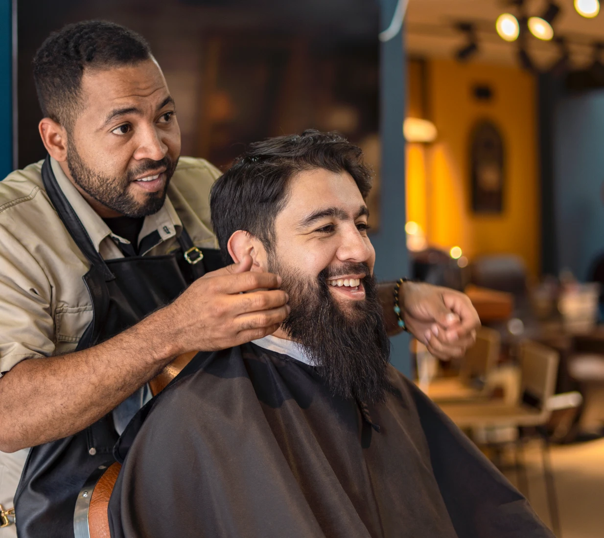 Barber styling customer's beard in shop